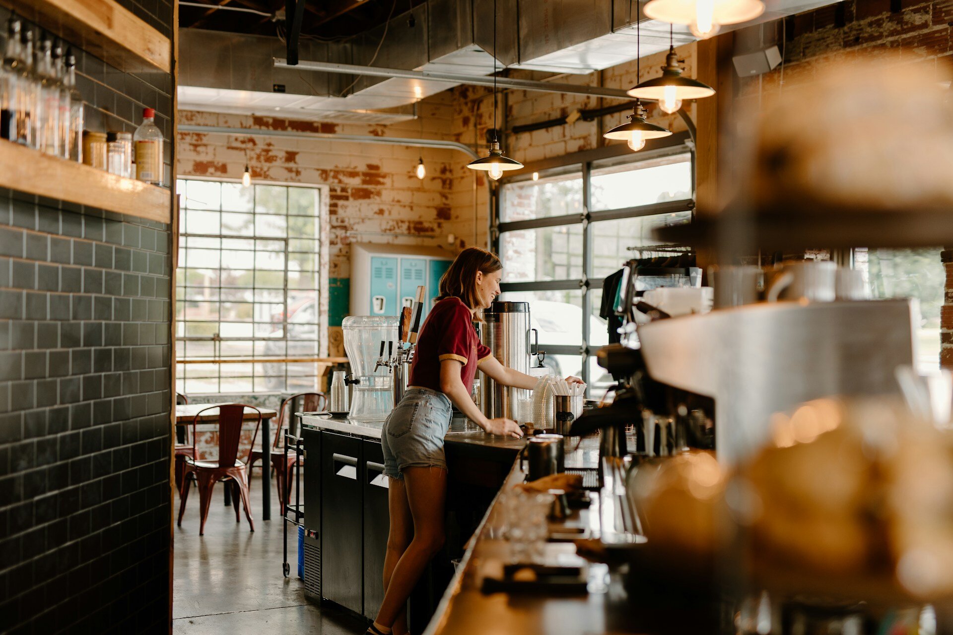 A barista in a cafe prepares drinks behind the counter.